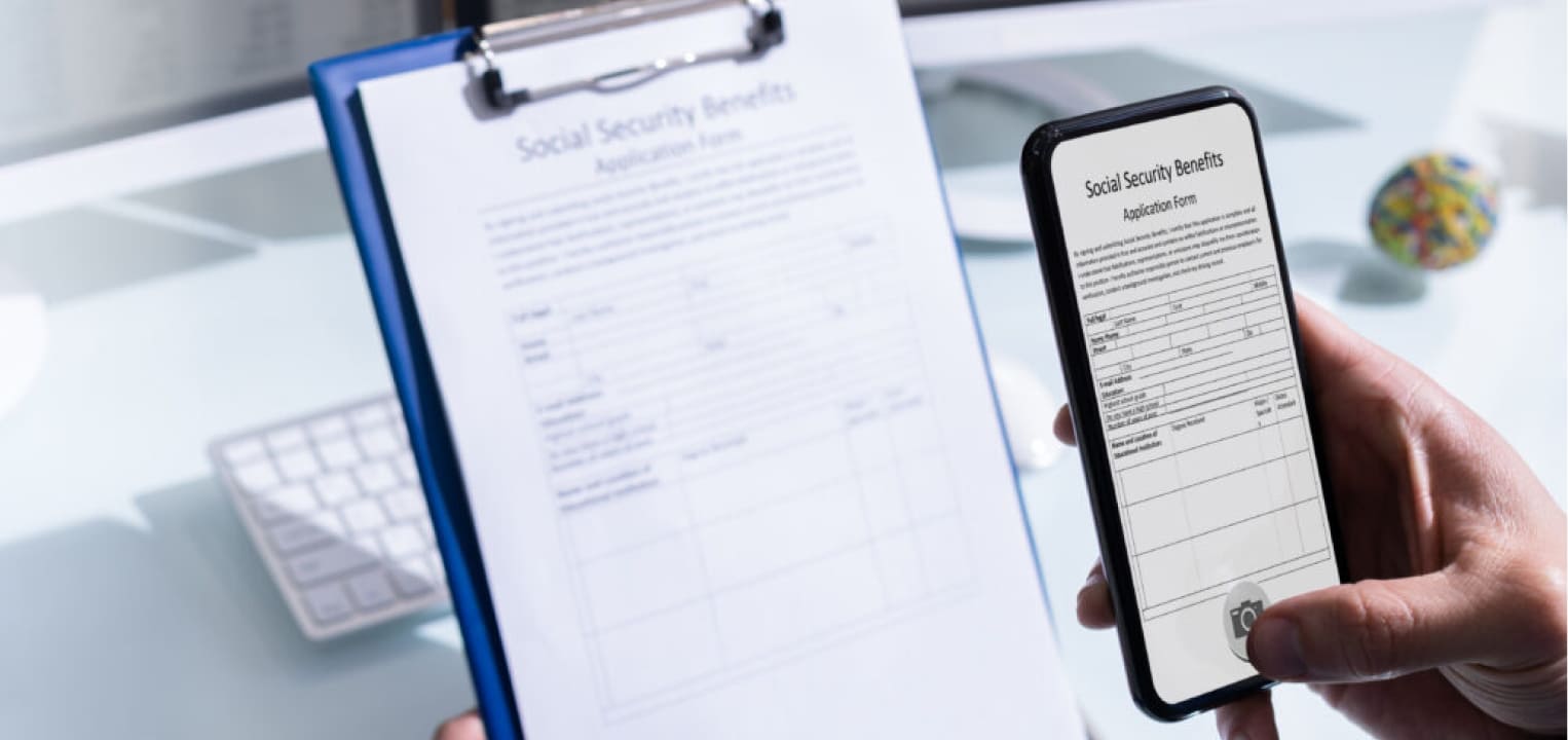 Person using a smartphone to scan a social security form.
