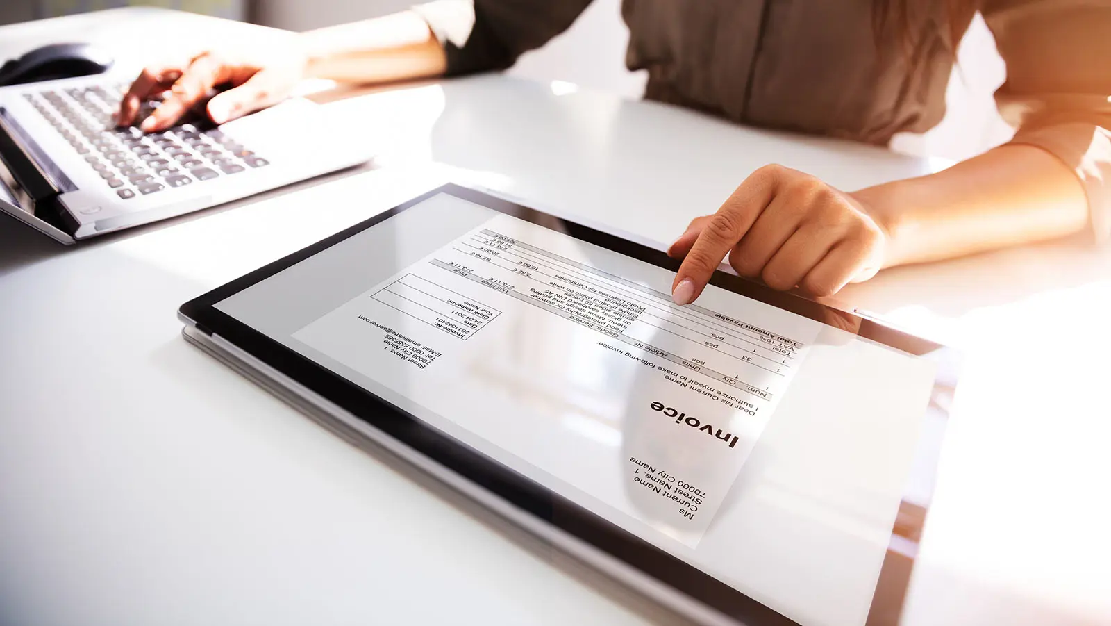 Person using AI-powered software to process invoices on a laptop.